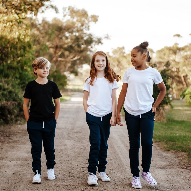 kids walking along a dirty path wear Frankie & Roy navy academy trackies school pants